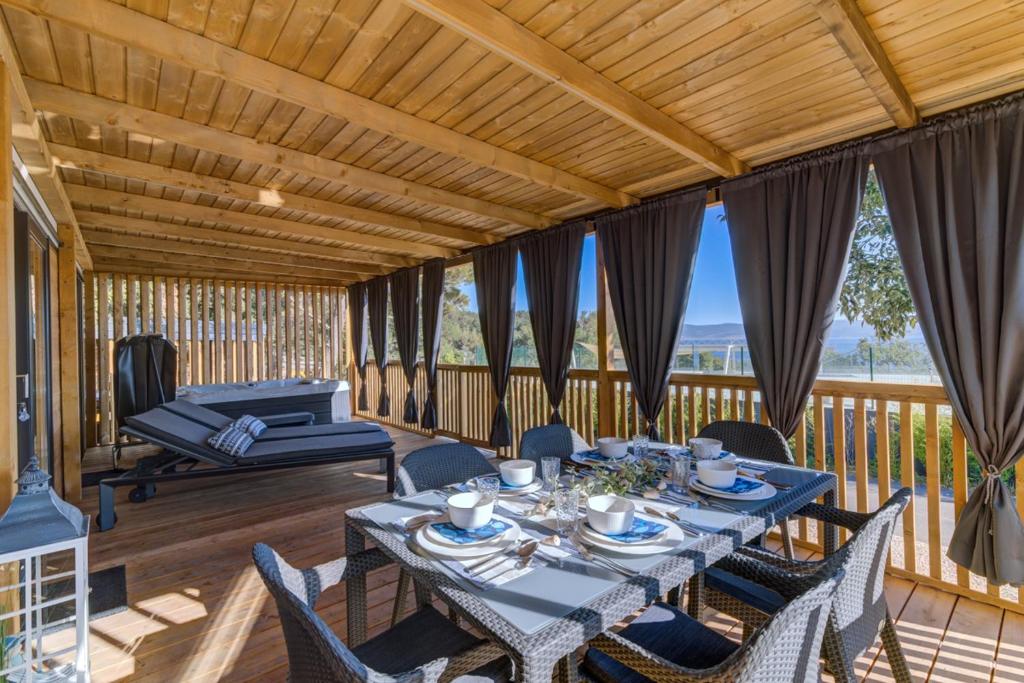 塞爾瑟的住宿－MOBILE HOMES SELCE - Alpe Jadran MOBIL，甲板上配有桌椅的用餐室