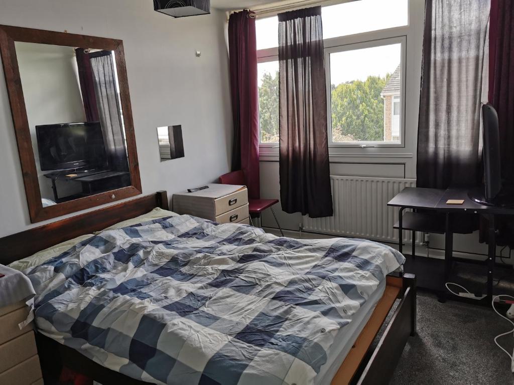 a bedroom with a bed and a desk and a window at Quiet room in Eltham in London