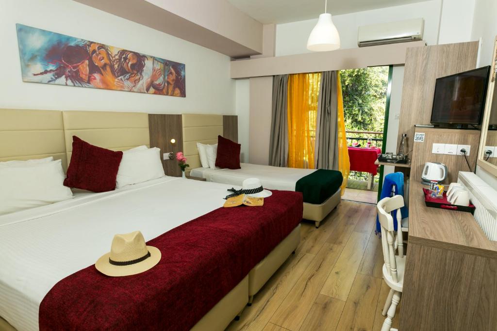 a hotel room with two beds with hats on them at Fitosinn Hotel in Paphos