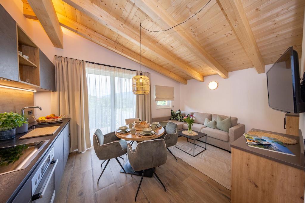 a kitchen and living room with a table and chairs at Lennis Apartments by we rent in Bruck an der Großglocknerstraße
