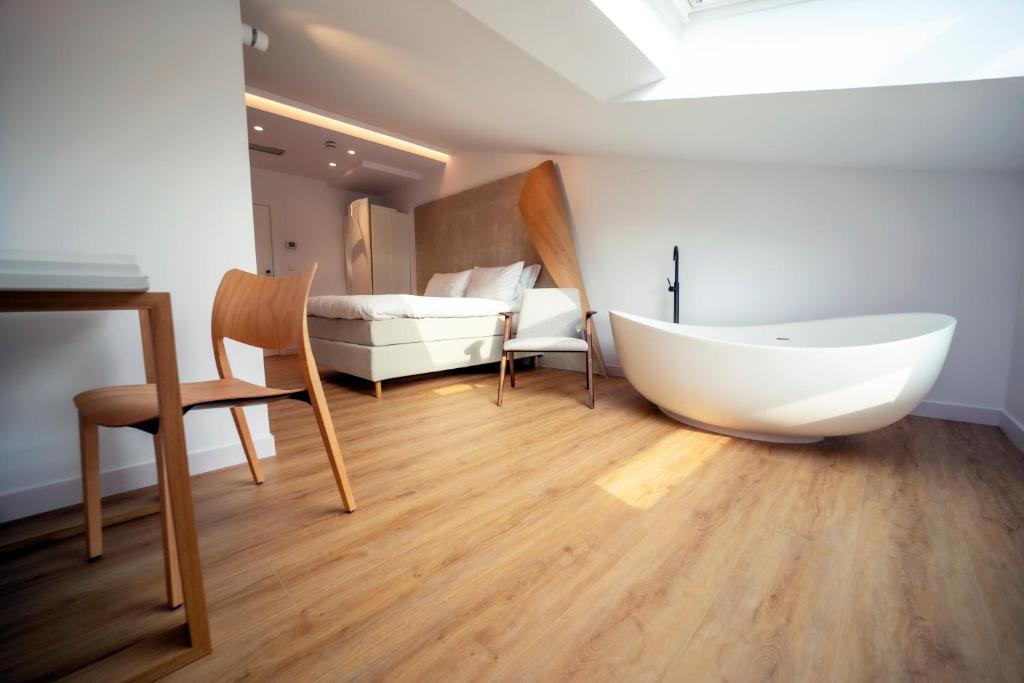 a room with a bath tub and a bedroom at Hotel Boutique Berazadi Berri in Zarautz