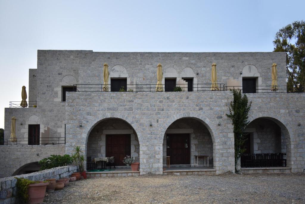 un edificio de piedra con arcos y ventanas. en Akroyiali Apartments, en Yerolimin