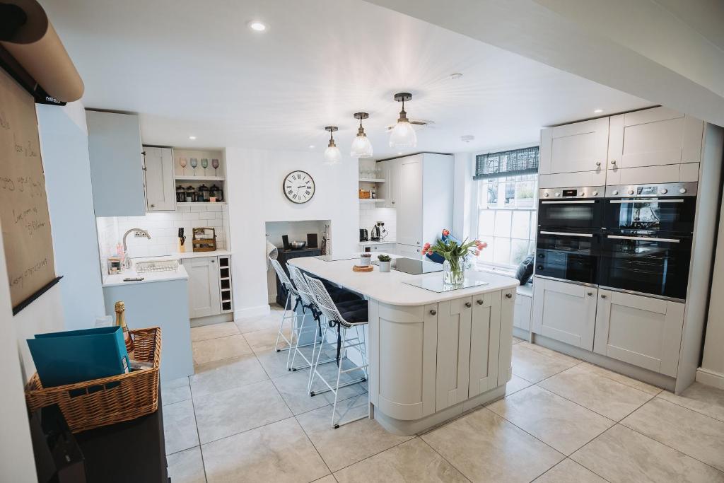 a kitchen with white cabinets and a white counter top at Stunning 5 bedroom period property by the sea in Kent