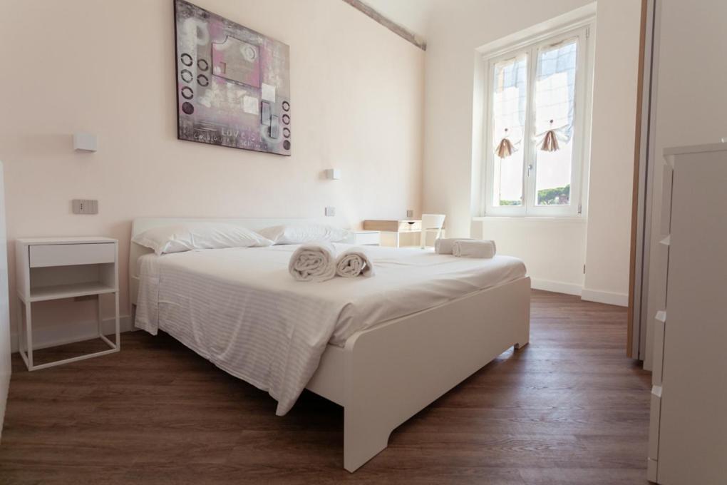 Un dormitorio blanco con una cama blanca y una ventana en InnPisaRentals - La Fortezza Apartment, en Pisa