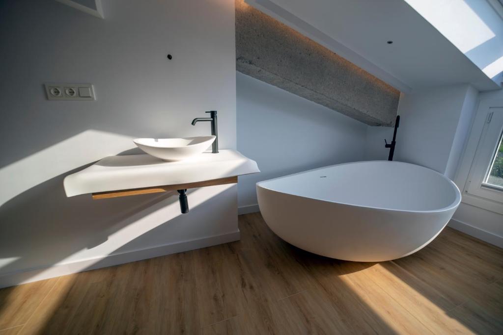 a bathroom with a white tub and a sink at Hotel Boutique Berazadi Berri in Zarautz