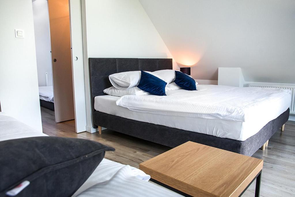 1 dormitorio con 2 camas con almohadas azules y mesa en Gorczańskie Wzgórze, en Niedźwiedź