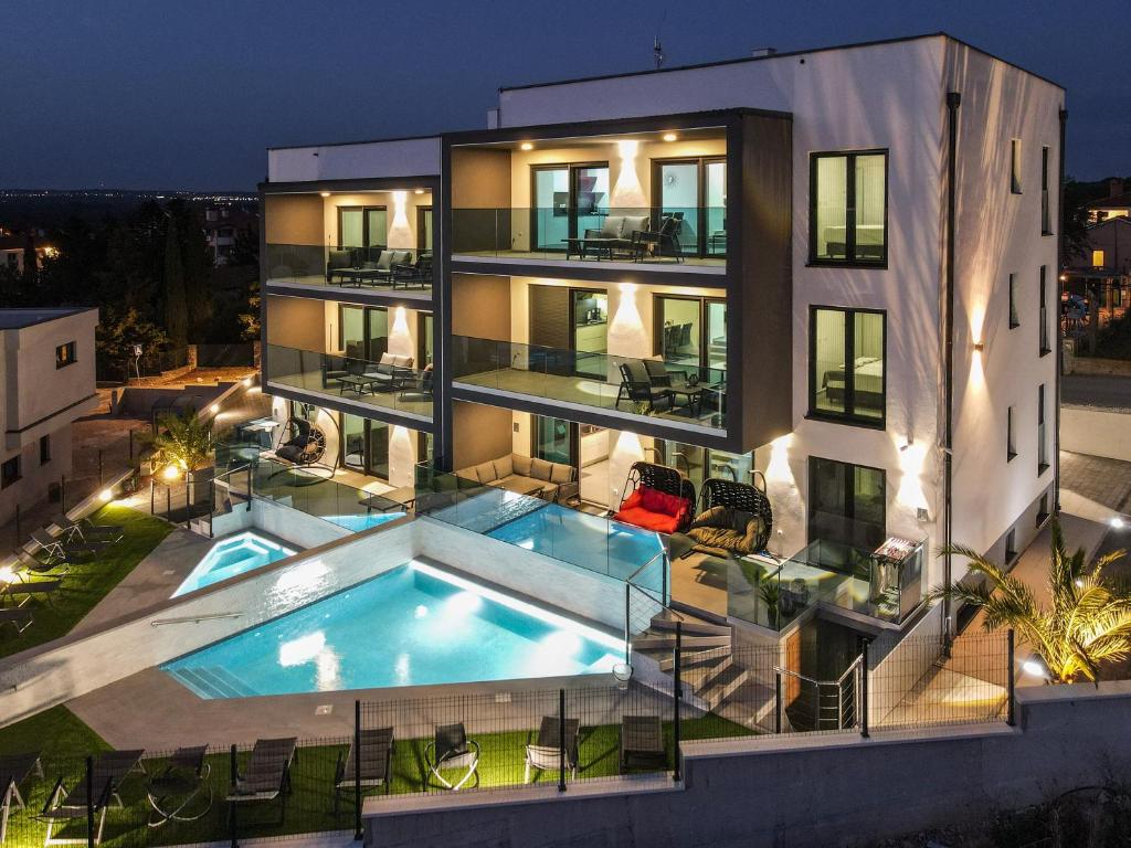 an apartment building with a swimming pool at night at PS Apartments in Pula