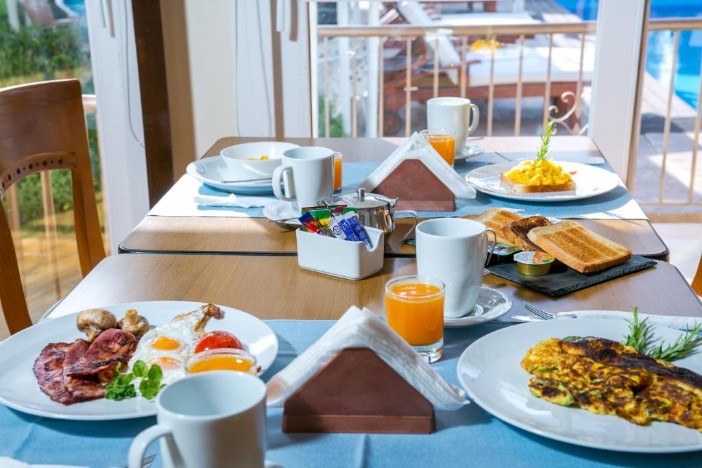 a table with plates of breakfast food on it at Fitosinn Hotel in Paphos