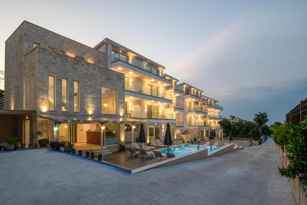 a large building with a swimming pool in front of it at Hanioti Central Hotel in Hanioti