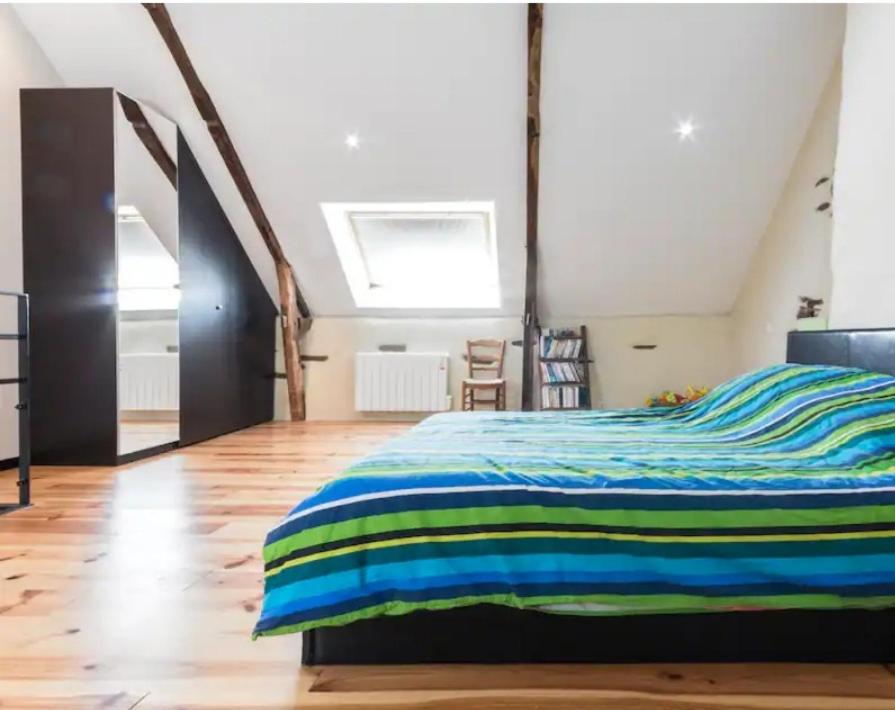 a bedroom with a bed with a striped blanket at Gite Kerlaguito in Pontchâteau