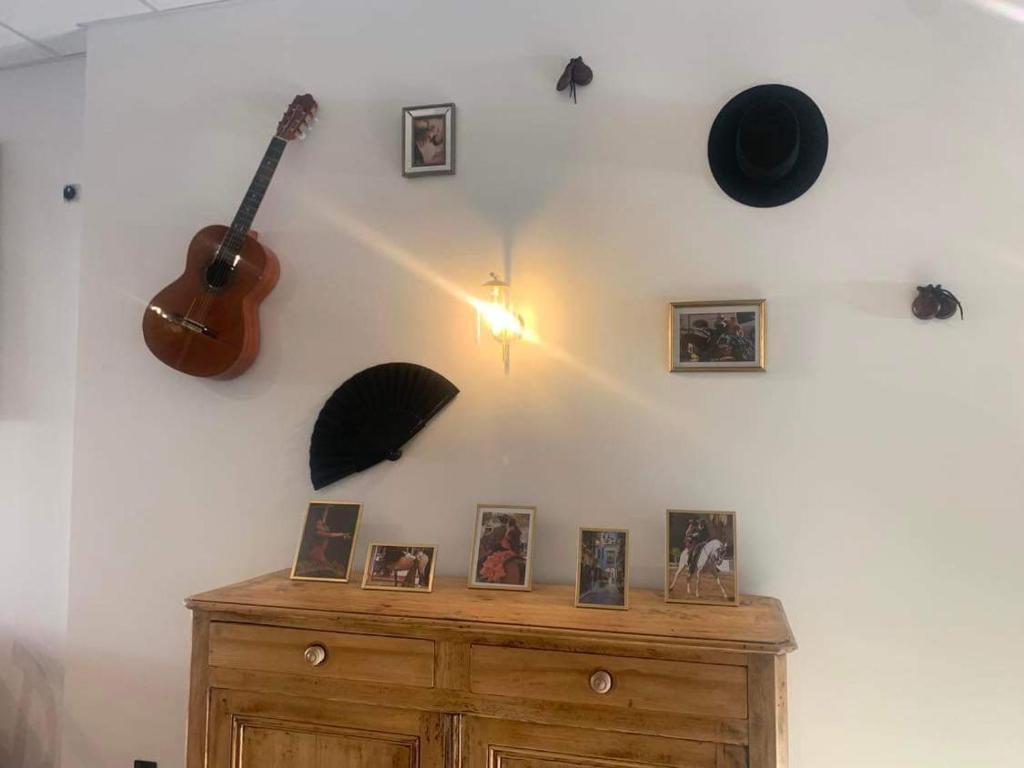 a room with a guitar and pictures on a wall at LE PATIO in Millau