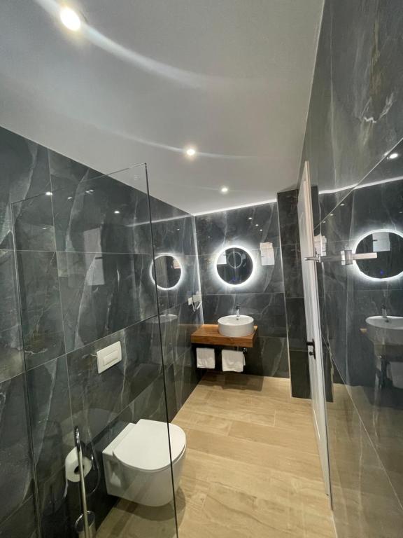 a bathroom with two sinks and a toilet and a shower at Hotel Villa Ruci in Ksamil