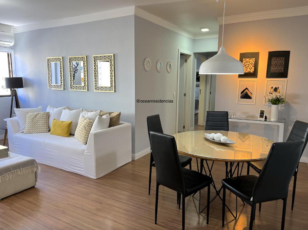 sala de estar con mesa y sofá blanco en Apartamento Decorado Coral, en Balneário Camboriú