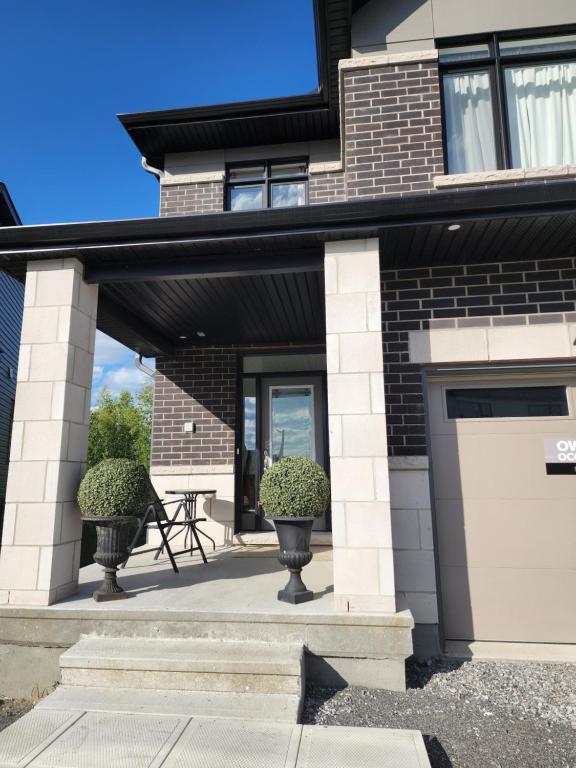 a house with a white garage door and some plants at Place You can call Home !!! Near Ottawa Airport in Ottawa