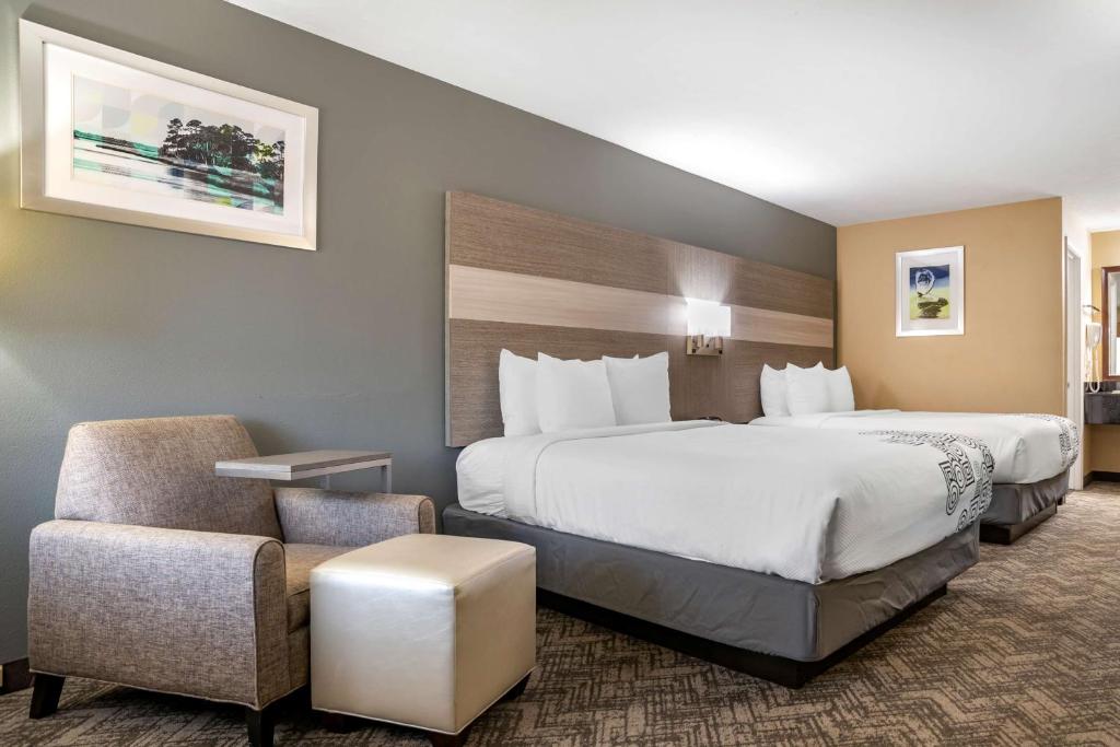 a hotel room with two beds and a chair at Best Western Apalach Inn in Apalachicola