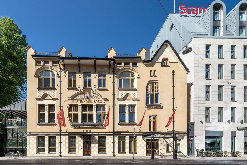un gran edificio con banderas frente a un edificio en Scandic Hamburger Börs en Turku