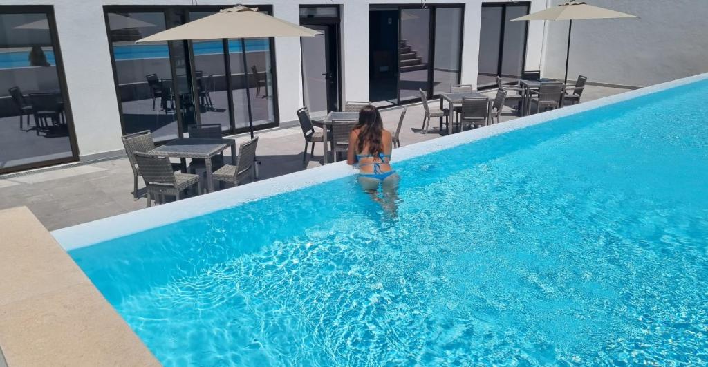 a woman in a bikini standing in a swimming pool at Casazul M&B in Cercal