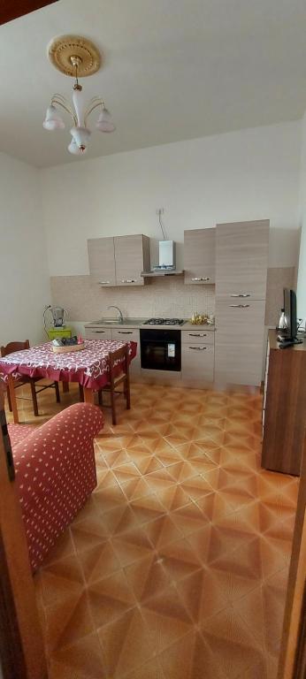 sala de estar con mesa y sillas y cocina en Casa Vacanza alloggio Casa Maria, en Sennori