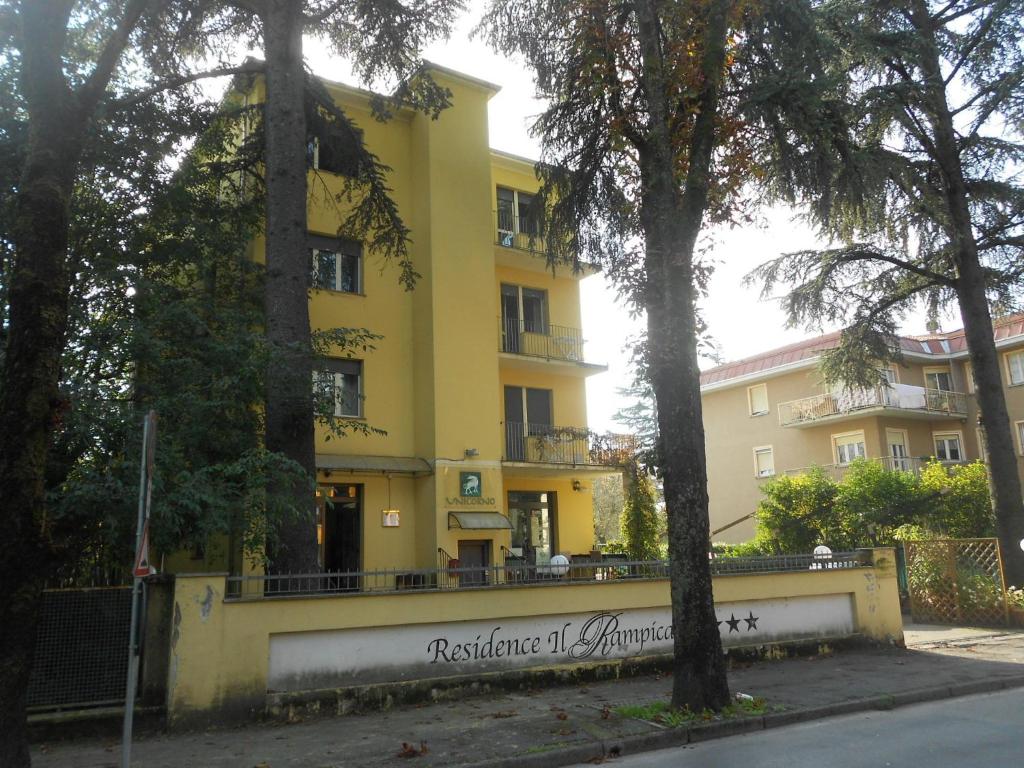 a yellow building with a sign in front of it at Residence Il Rampicante in Monticelli Terme