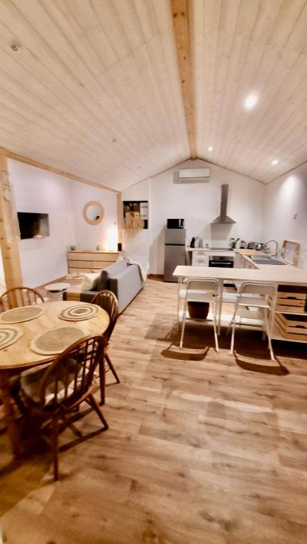 une cuisine et un salon avec une table et des chaises dans l'établissement Le Cosy Porgeais, à Le Porge