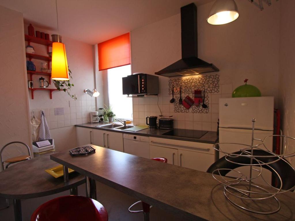 uma cozinha com uma mesa e um frigorífico em Gîte Épinal, 3 pièces, 5 personnes - FR-1-589-92 em Épinal