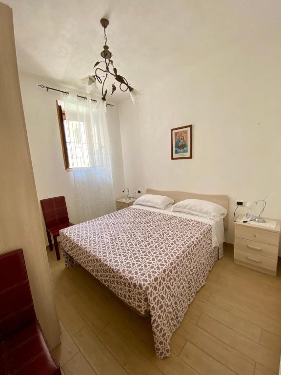 - une chambre avec un lit et un lustre dans l'établissement Casa Vacanza di Iside, à Montegiordano