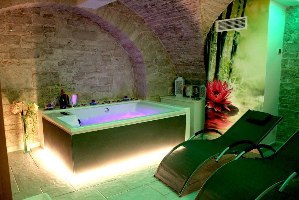 un ampio bagno con vasca in un muro di mattoni di Rubis Relais & SPA a Ruvo di Puglia