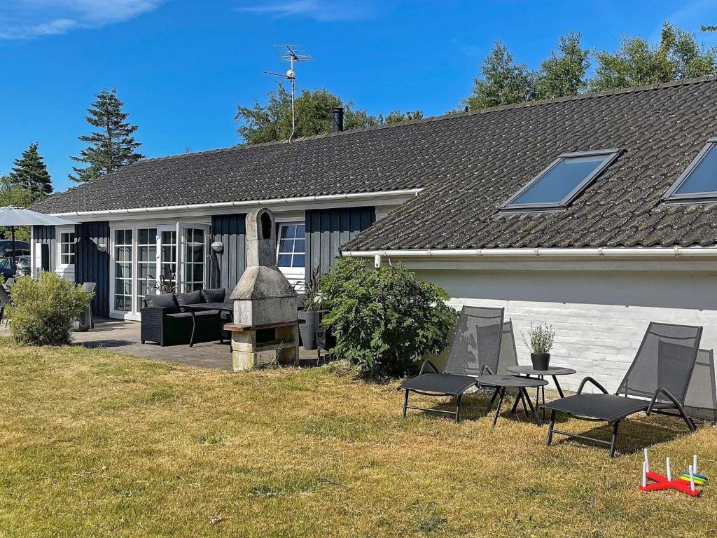 10 person holiday home in rsted في Ørsted: منزل به كرسيين وطاولة في الفناء