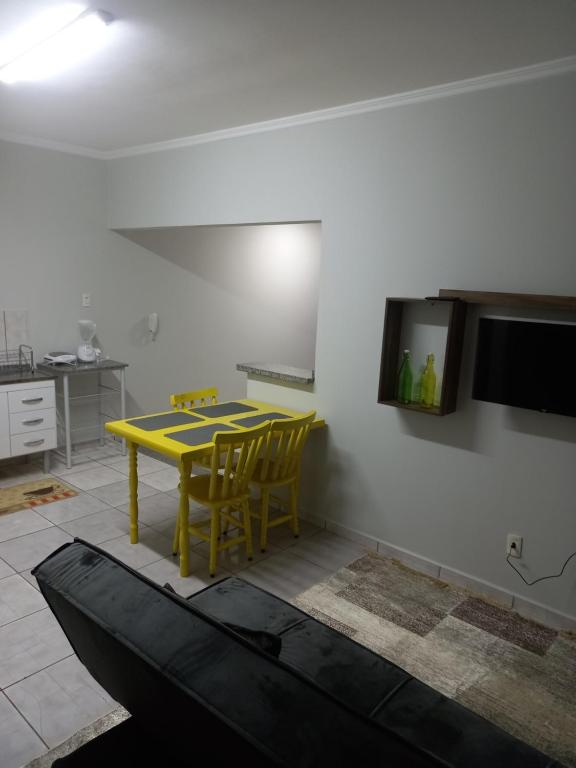 a kitchen with a yellow table and yellow chairs at Residencial Joed 2 in Dourados