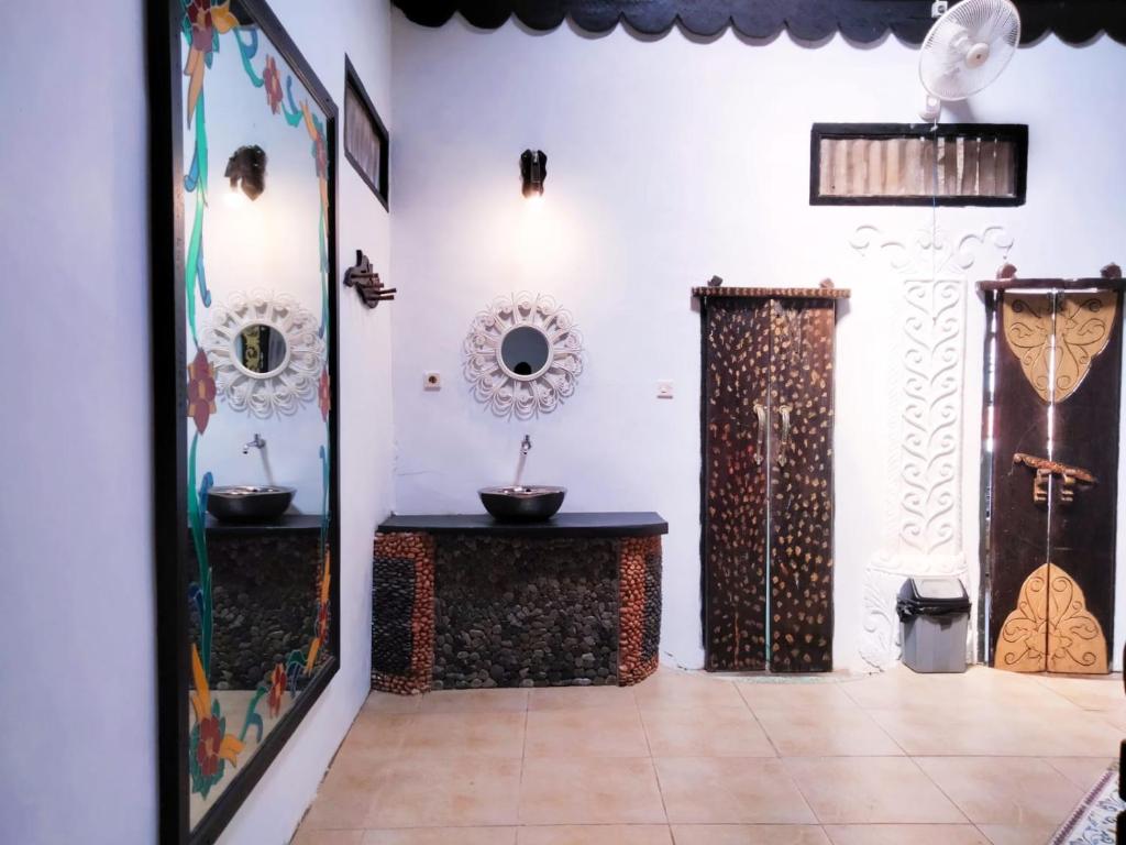 a bathroom with two sinks and a mirror at Jungle Inn Bukit lawang in Bukit Lawang