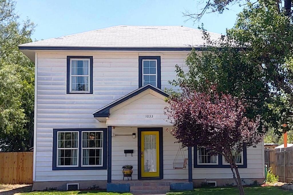 une maison blanche avec une porte jaune dans l'établissement Oma's House on Orange, à Abilene