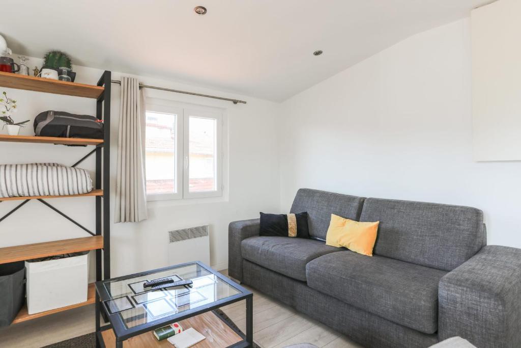 un salon avec un canapé et une table en verre dans l'établissement Beau studio refait à neuf en plein coeur de Nice - Welkeys, à Nice