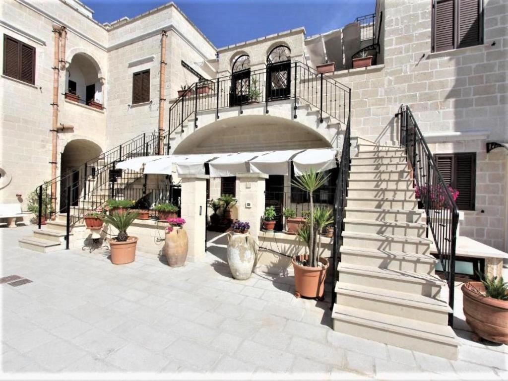 un edificio con una escalera y macetas en Characteristic apartments in Salento just a few minutes from the sea, en Diso