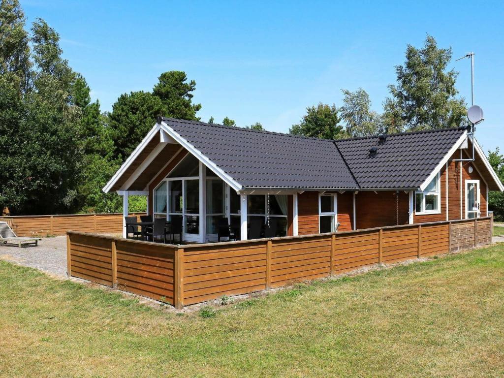 a house with a large wooden deck with a porch at 8 person holiday home in Idestrup in Marielyst