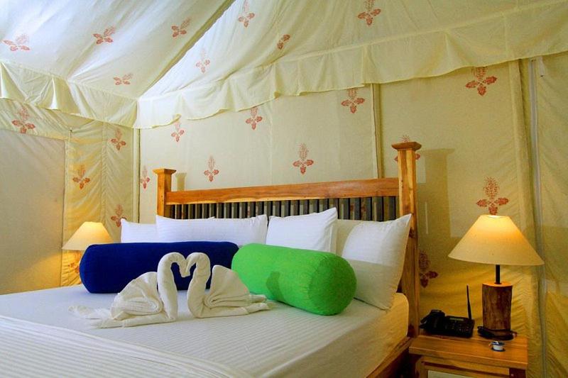 - une chambre avec un lit doté de deux oreillers en cygne dans l'établissement Green villa yala, à Tissamaharama