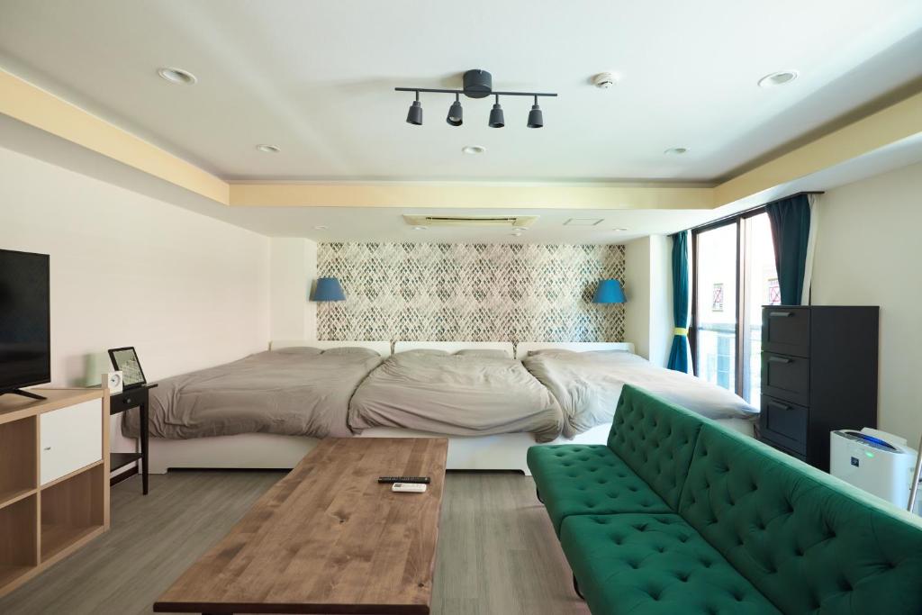 1 dormitorio con 1 cama y 1 sofá verde en Evergreen Shinjuku Luxe #2m14, en Tokio
