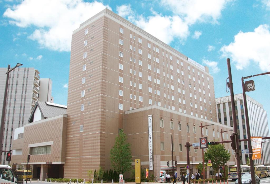 a large building on the corner of a street at Hotel The West Hills Mito in Mito