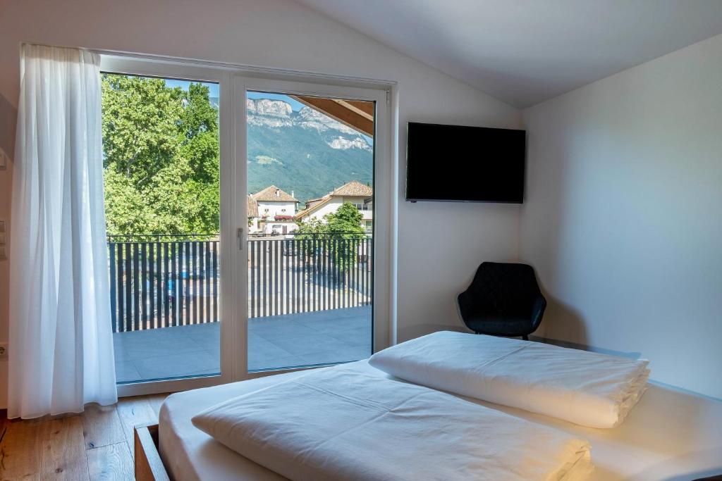 a bedroom with a bed and a large window at Luisl Hof - Apartment Pomum in Cornaiano