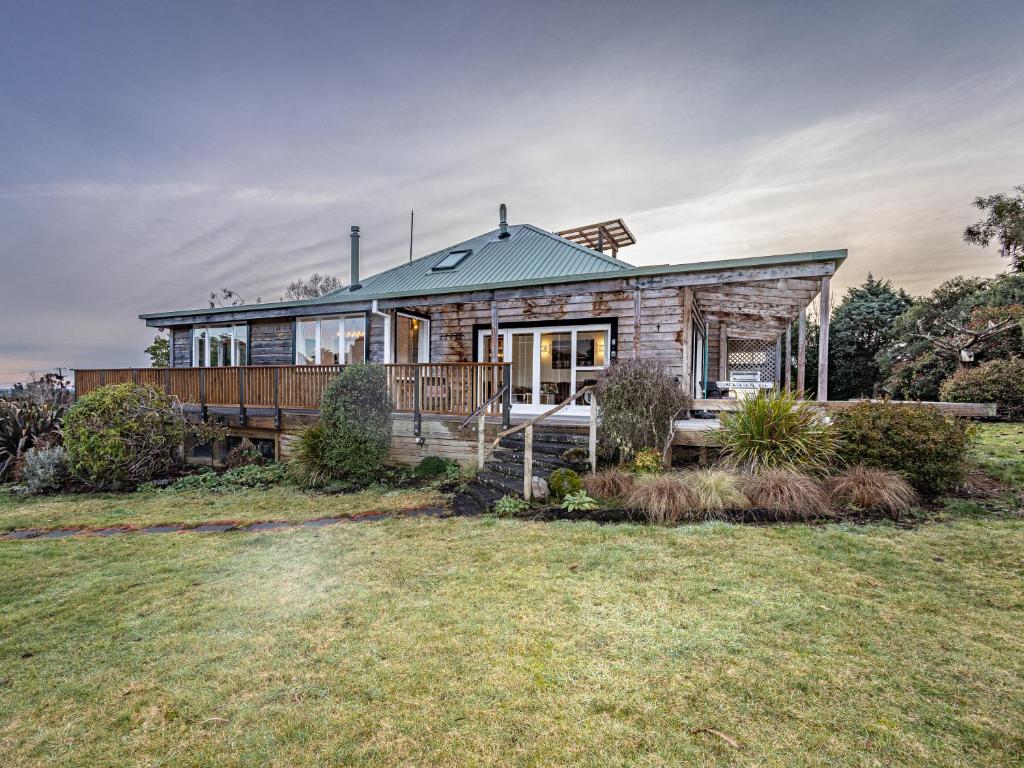 a brick house with a porch and a deck at Rivendell - Horopito Holiday Home in Ohakune
