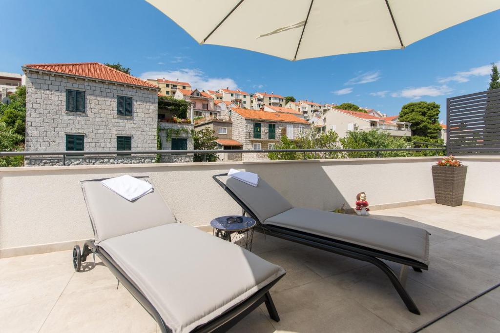 - deux chaises sur un balcon avec vue sur la ville dans l'établissement Apartment Gloria, à Dubrovnik