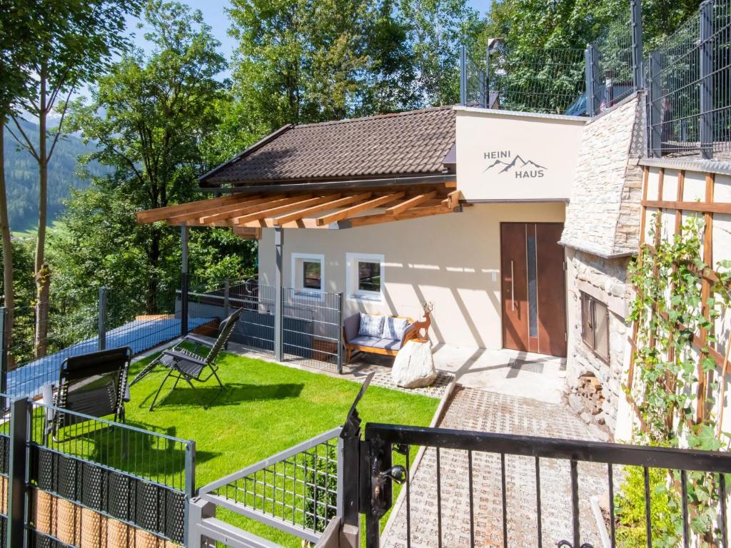 a view of a house with a patio and a fence at Alpine Holiday Home in Bramberg am Wildkogel with Garden in Bramberg am Wildkogel