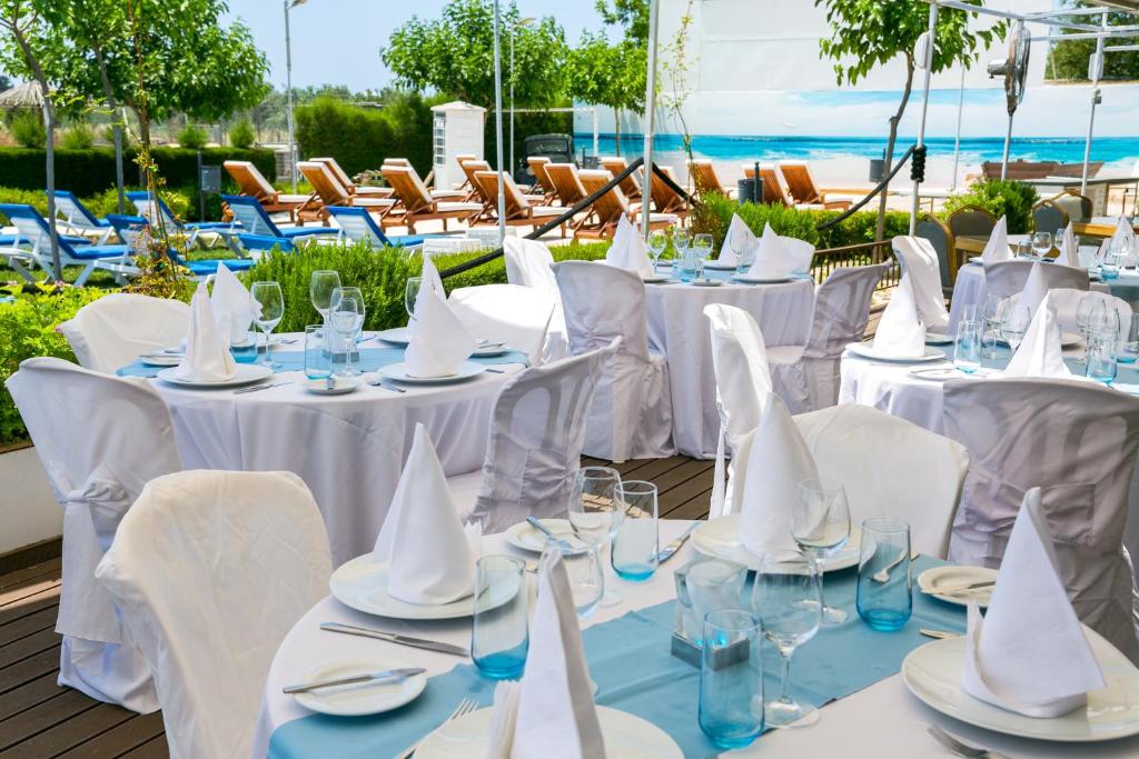 a table set up for a wedding with white tables and chairs at Fitosinn Hotel in Paphos