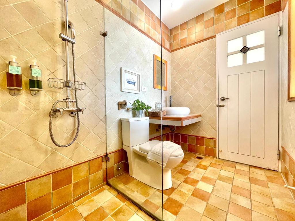 a bathroom with a shower and a toilet and a sink at SpoonDrift Hostal Kenting in Nanwan