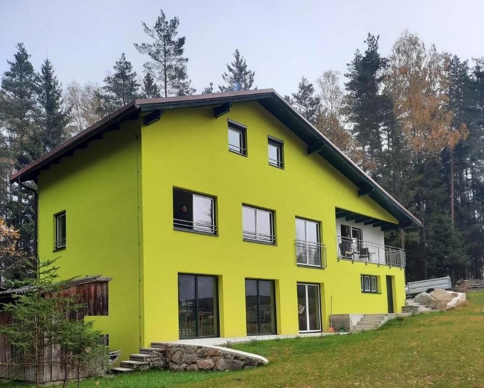 una casa gialla con tetto nero di Ferienwohnungen Susanna Haubner a Litschau