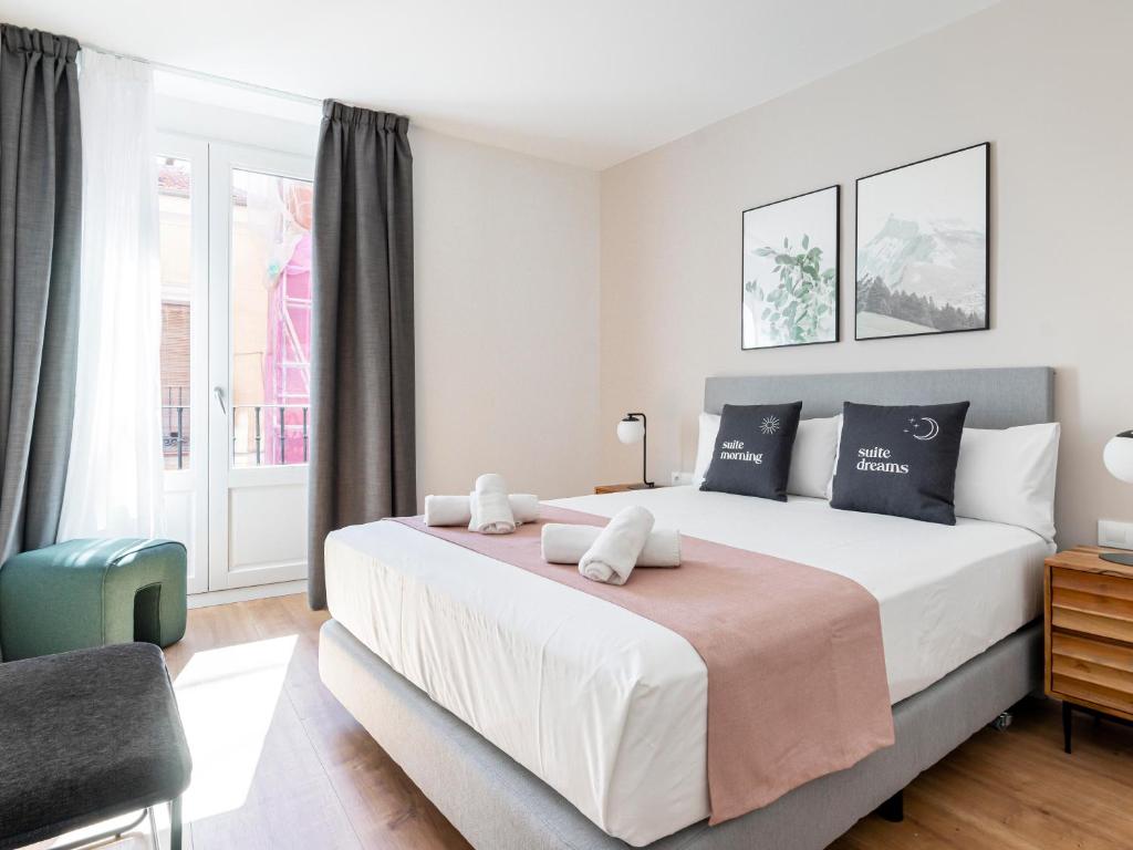 een slaapkamer met een groot bed en een raam bij limehome Madrid Calle de Fomento - Digital Access in Madrid