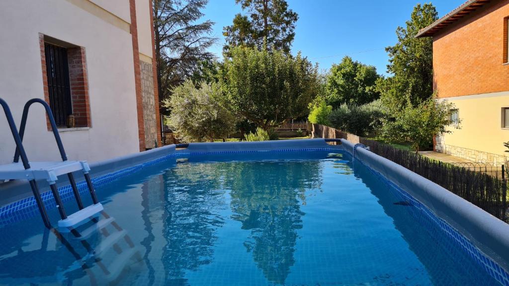 una piscina de agua azul en un patio en VAL D'ORCIA DELUXE 2, RAFFINATA CASA immersa nel verde con WiFi, giardino e parcheggio, en Montalcino