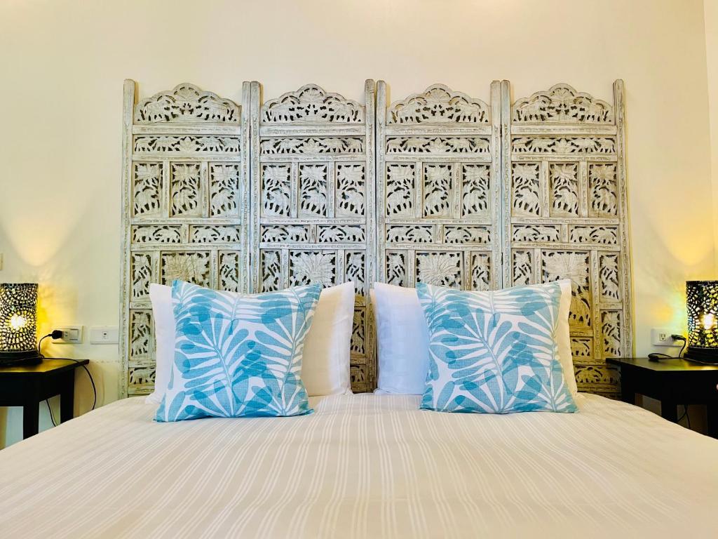 a bed with blue and white pillows in a bedroom at SpoonDrift Hostal Kenting in Nanwan