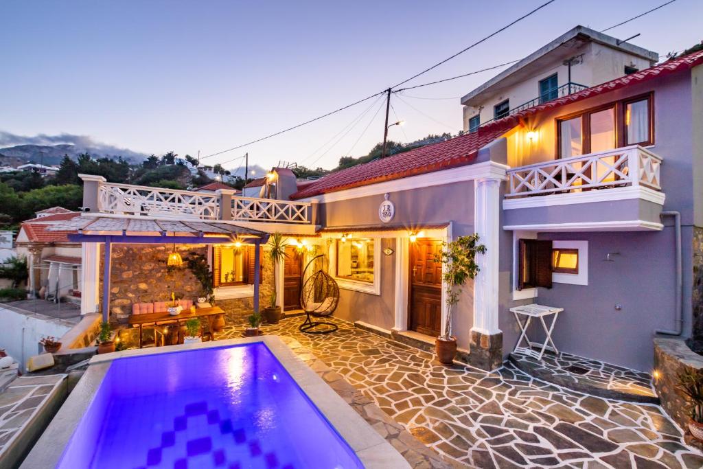 a villa with a swimming pool in front of a house at Villa Anastasia in Voládha