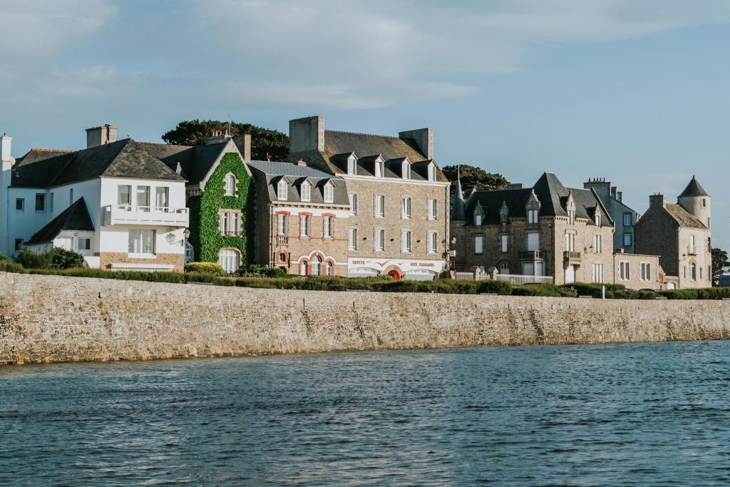 un groupe de maisons à côté d'une masse d'eau dans l'établissement Hôtel Aux Tamaris - Vue Mer, à Roscoff