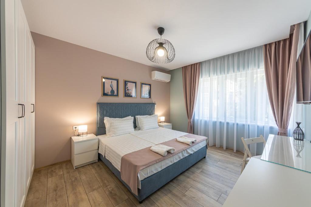 a bedroom with a large bed and a window at Great Location Apartment in Varna City